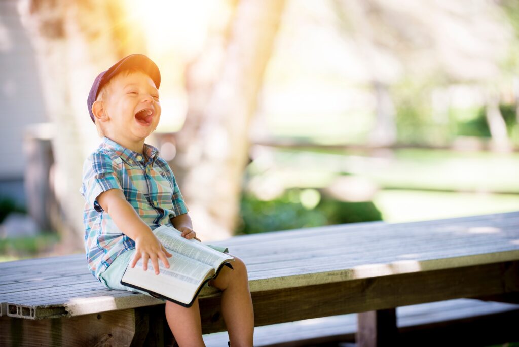 Kid laughing with a book