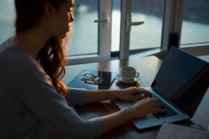 Woman at her computer on a desk in a dark setting