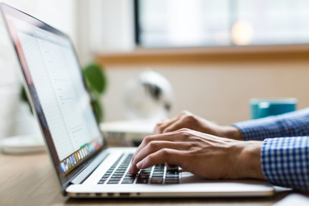 person typing on macbook